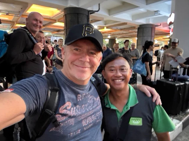 Two people smiling together in a busy arrival hall