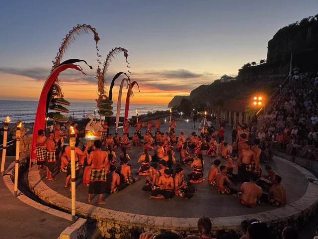 A traditional outdoor performance beside the sea at sunset